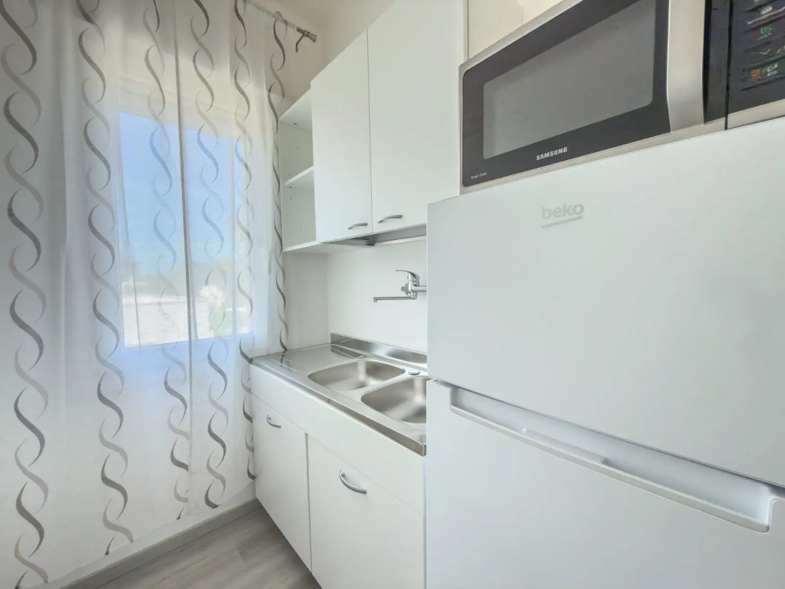 Angolo cucina comune con frigorifero e microonde