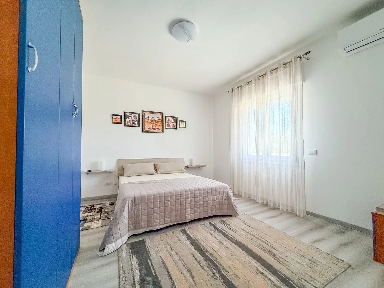 Camera luminosa con letto matrimoniale e armadio blu